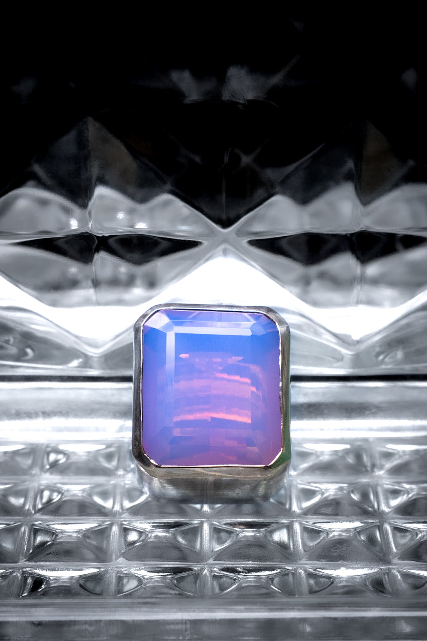 Ring with a colorful gemstone on a textured metallic surface