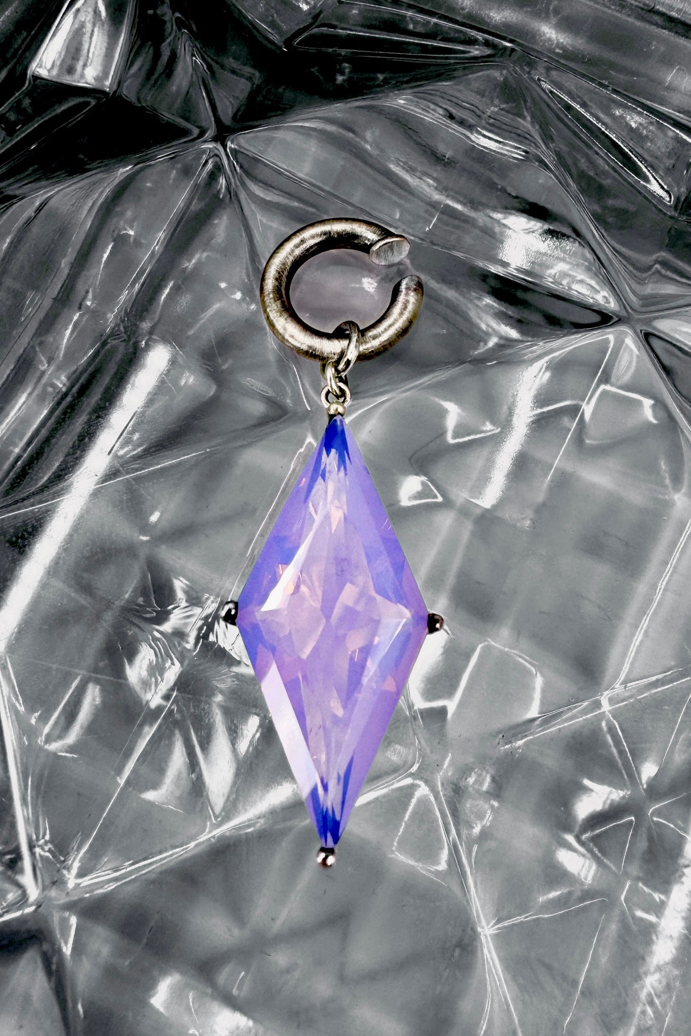 Ear cuff with a periwinkle gemstone on a textured silver background